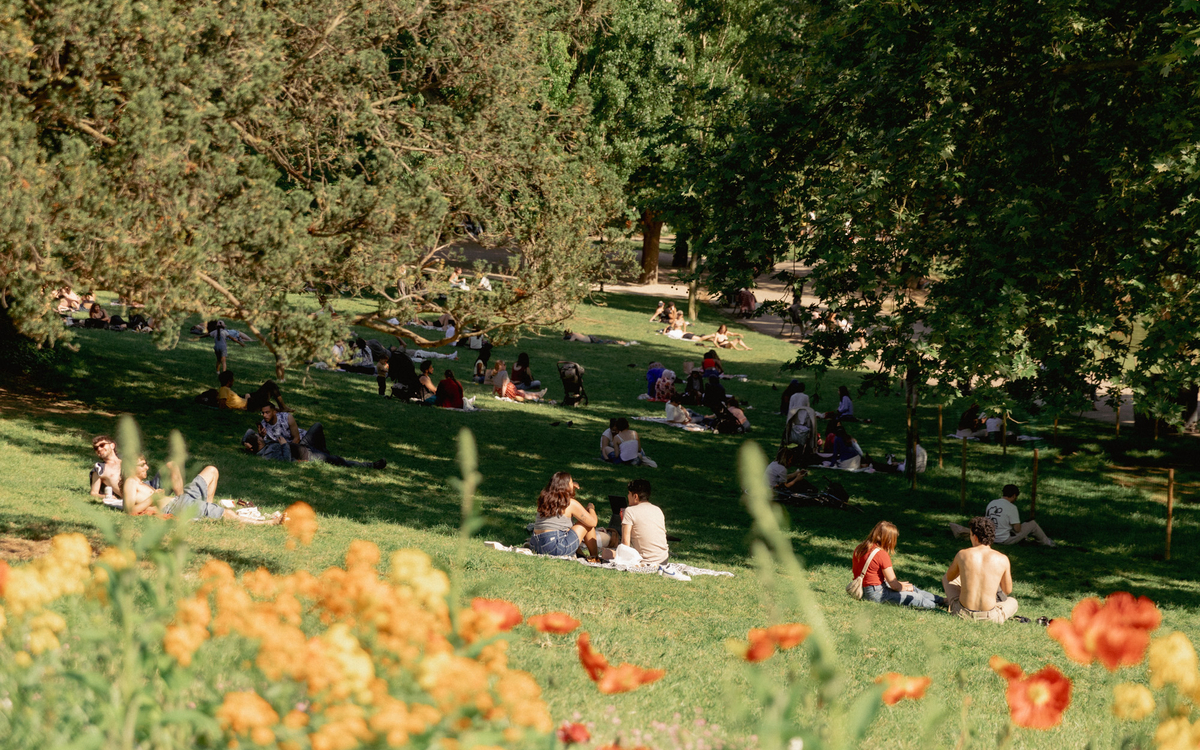 Repos au soleil sur les pelouses du parc des Buttes Chaumont.