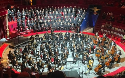 La photo représente le chœur et orchestre symphonique de Paris : on y voit un orchestre de 50 musiciens ainsi qu'une centaine de choristes.